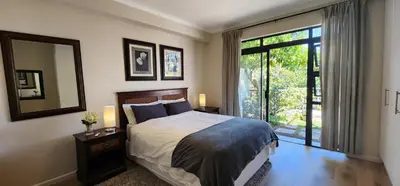 a bedroom with a bed and a large window at Waterside Townhouse in Cape Town