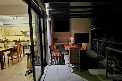 a balcony with a table and chairs in a kitchen at Waterside Townhouse in Cape Town