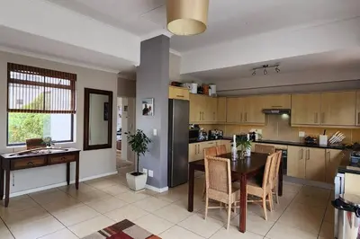 a kitchen with a table and a dining room at Waterside Townhouse in Cape Town