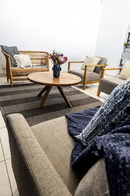 a living room with couches and a coffee table at Spacious beachfront Townhouse w garage, Blouberg in Bloubergstrand