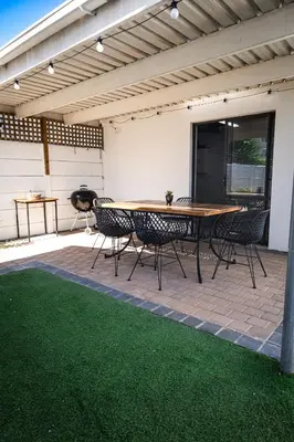 a patio with a table and chairs under awning at Spacious beachfront Townhouse w garage, Blouberg in Bloubergstrand