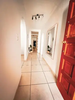 a hallway with a tile floor and a red door at Spacious beachfront Townhouse w garage, Blouberg in Bloubergstrand