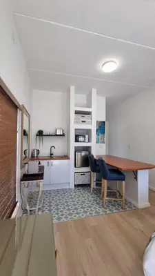 a kitchen and living room with a table and chairs at @5 on Lincoln in Cape Town