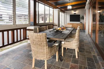 a dining room with a wooden table and chairs at Avemore Manor House wood fired hot tub magical views and full Backup power in Stellenbosch