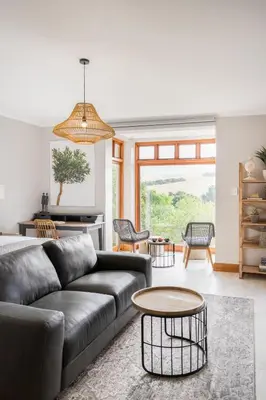 a living room with a couch and a table at Avemore Manor House wood fired hot tub magical views and full Backup power in Stellenbosch
