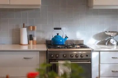 a blue tea kettle sitting on top of a stove in a kitchen at Fransmanskraal Accommodation - Luxury Stellenbosch Farm Villa in Stellenbosch