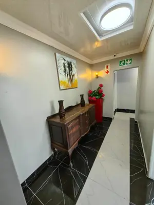 a hallway of a building with a door and flowers at Essential Lodge23 in Cape Town