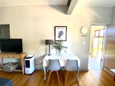 a dining room with a white table and chairs at Stay on Main 1 in Paarl