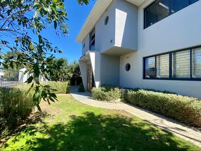 a white house with a green yard at Stay on Main 1 in Paarl