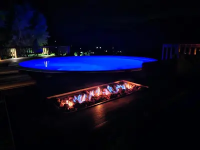 a swimming pool and a fire pit at night at Valley View Eco Country Estate - Paradise in the Winelands in Villiersdorp