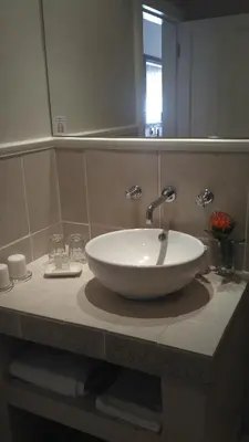 a white sink in a bathroom with a mirror at Evertsdal Guesthouse in Durbanville