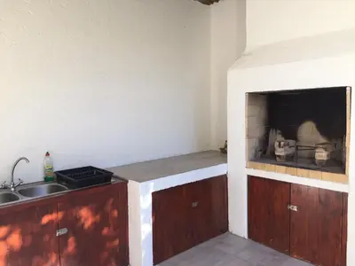 a kitchen with a sink and a counter with a fireplace at Haven of Peace and Garden Cottage in Hermanus