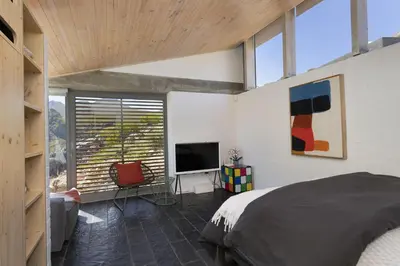 a bedroom with a bed and a flat screen tv at Hytte Riverview in Rooiels