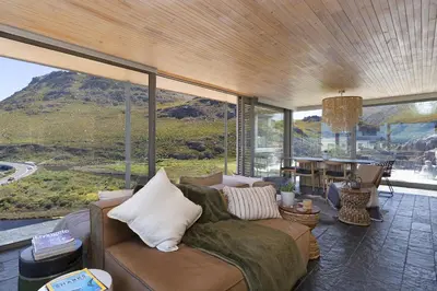 a living room with a couch and a table at Hytte Riverview in Rooiels