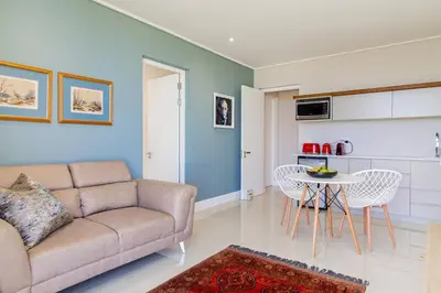 a living room with a couch and a table at The View, Apartment, with magnificent sea view in Hermanus