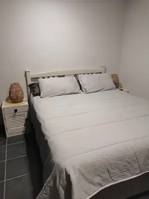 a bedroom with a large white bed with a night stand at Ruach 5 in Cape Town