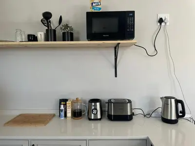 a kitchen counter with a microwave and appliances on it at Ruach 5 in Cape Town