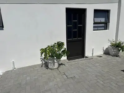 a door and two potted plants in front of a building at Ruach 5 in Cape Town