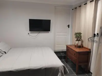 a bedroom with a bed and a tv on the wall at Ruach 5 in Cape Town