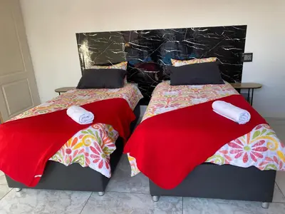 two beds sitting next to each other in a room at Stay at Gabby's- no loadshedding in Cape Town