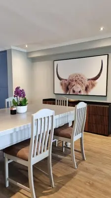 a dining room with a cow on the wall at Pearl Valley Golf Lodge - loadshedding free in Simondium