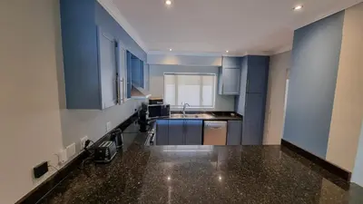 a kitchen with blue cabinets and a sink at Pearl Valley Golf Lodge - loadshedding free in Simondium