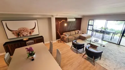 a living room with a painting of a bull on the wall at Pearl Valley Golf Lodge - loadshedding free in Simondium