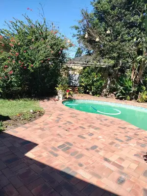 a backyard with a swimming pool and a brick patio at Near Grandwest in Cape Town