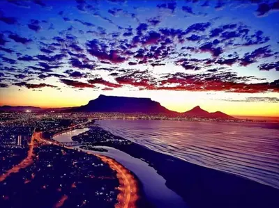 a view of the beach with the sunset in the background at Villa Georgia in Cape Town