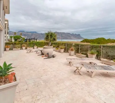 a group of benches sitting on a patio overlooking the ocean at Villa Georgia in Cape Town