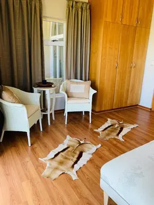 a living room with a wooden floor with two dogs laying on the floor at Villa Georgia in Cape Town
