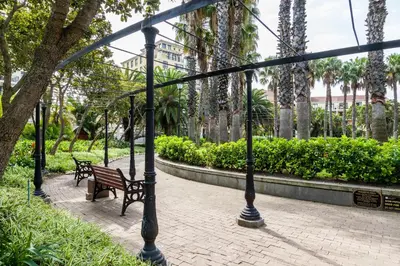 a park with two benches and a street light at Island Club Hotel & Apartments in Cape Town