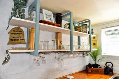 a kitchen with blue shelves on the wall at Seaview on 2822 Happy Whale Cottage in Bettyʼs Bay