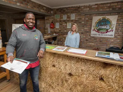 a man standing in front of a table with hay at Old Mac Daddy in Botrivier