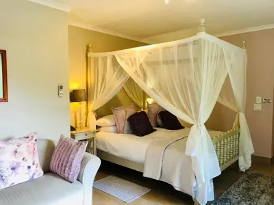 a bedroom with a canopy bed and a couch at Dunstone Estate in Wellington