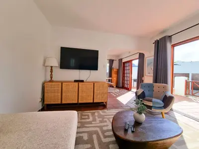 a living room with a tv and a couch and a chair at 2 Barford Haven in Hermanus