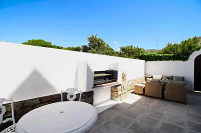 a bathroom with a toilet and a television on a wall at 2 Barford Haven in Hermanus
