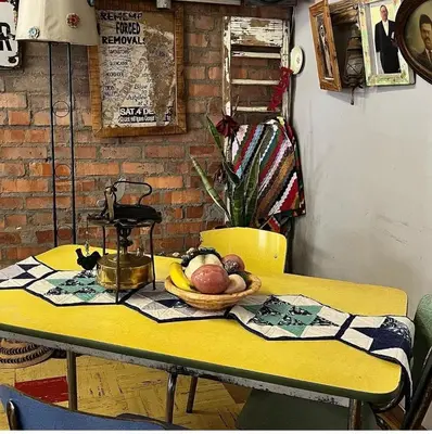 a yellow table with a bowl of fruit on it at Suzies Huis Restaurant Bed and Breakfast in Cape Town