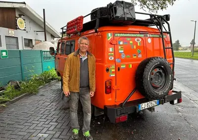 a man standing in front of an orange vehicle at Suzies Huis Restaurant Bed and Breakfast in Cape Town