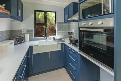 a blue kitchen with a sink and a stove at The Blue Cabin in Fisherhaven
