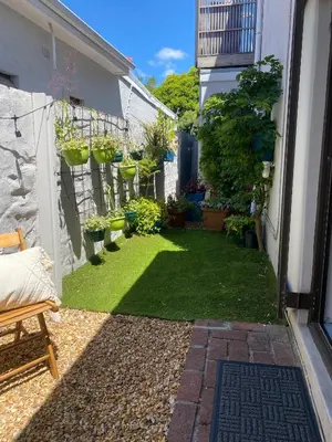 a garden with potted plants on the side of a building at Milner Cottage: Digital Nomad Oasis in Cape Town
