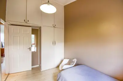 a bedroom with a bed and a white closet at Pearlmar Views in Cape Town
