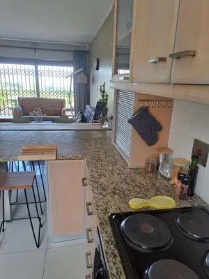 a kitchen and living room with a stove top oven at Pearlmar Views in Cape Town