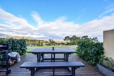 a wooden deck with a picnic table on it at Pearlmar Views in Cape Town