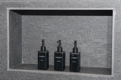three black bottles sitting on a shelf in a wall at Oranje Meul in Paarl