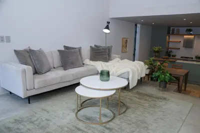 a living room with a white couch and a table at Oranje Meul in Paarl