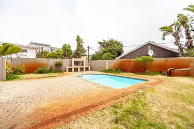 a swimming pool in the backyard of a house at Beachfront 3rd floor 2 bedroom w communal swimming pool- B16 Blouberg in Bloubergstrand