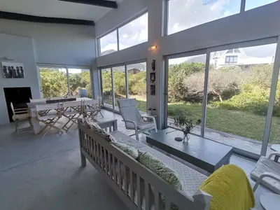 a living room with a couch and a table at Betty's Bay Cottage in Bettyʼs Bay