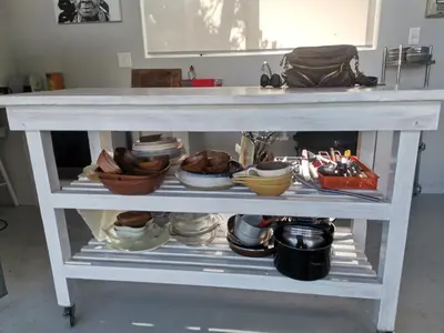 a white table with bowls and dishes on a shelf at Betty's Bay Cottage in Bettyʼs Bay