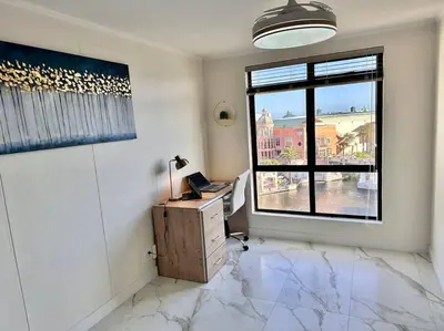 an empty room with a desk and a window at 30% off Designer Penthouse - backup power - Cape Town in Cape Town